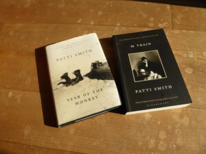 Patti Smith "The Year of the Monkey" und "M Train" auf einem sonnigen Holzfußboden.