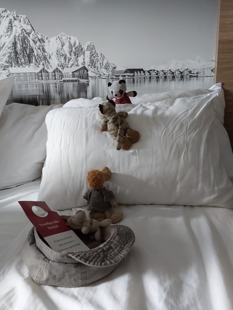 Vier Freunde auf Klettertour im Bett: Vom Basislager in der Kappe erklimmen ein sehr kleiner Löwe, ein Löwe mit Ringelshirt und ein Tiger einen "Kissenberg", auf dessen Gipfel sie ein Panda in Latzhose erwartet