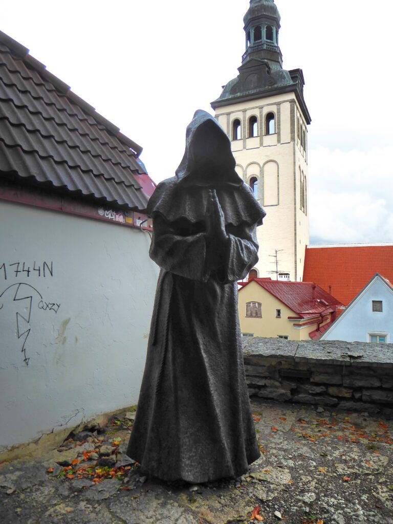 Ein weiterer Mönch betet auf dem Plateau oberhalb der Altstadt. Zwar sieht man seine betenden Hände, doch sein Kopf und Gesicht bleiben im Dunkel der Kapuze verborgen.